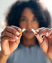 Woman breaking cigarette in half