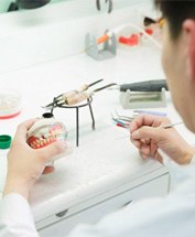 a dental technician working on the denture creation process