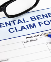 Dental benefits insurance claim form with pen and glasses