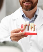 a dentist demonstrating how dental implants work