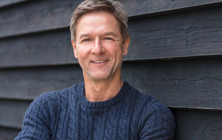 Man smiling after replacing missing teeth