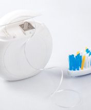 Toothbrush and dental floss on a white table