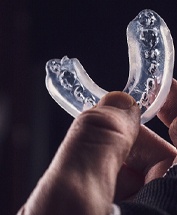 Holding an athletic mouthguard in right hand
