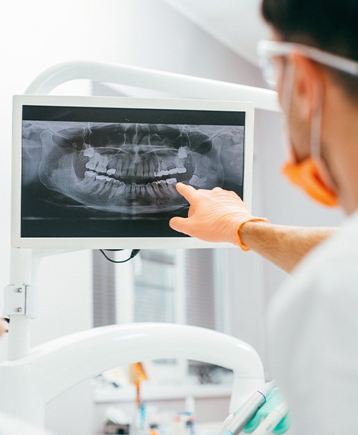 Dentist pointing to digital x-rays