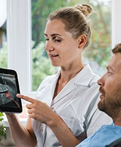 A dentist showing a patient an X-ray of his wisdom teeth
