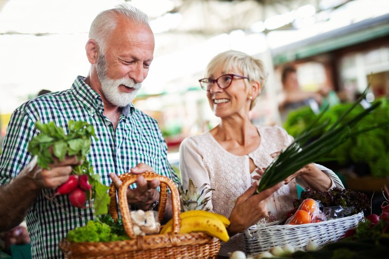 Couple grocery shopping for dental implant-friendly foods