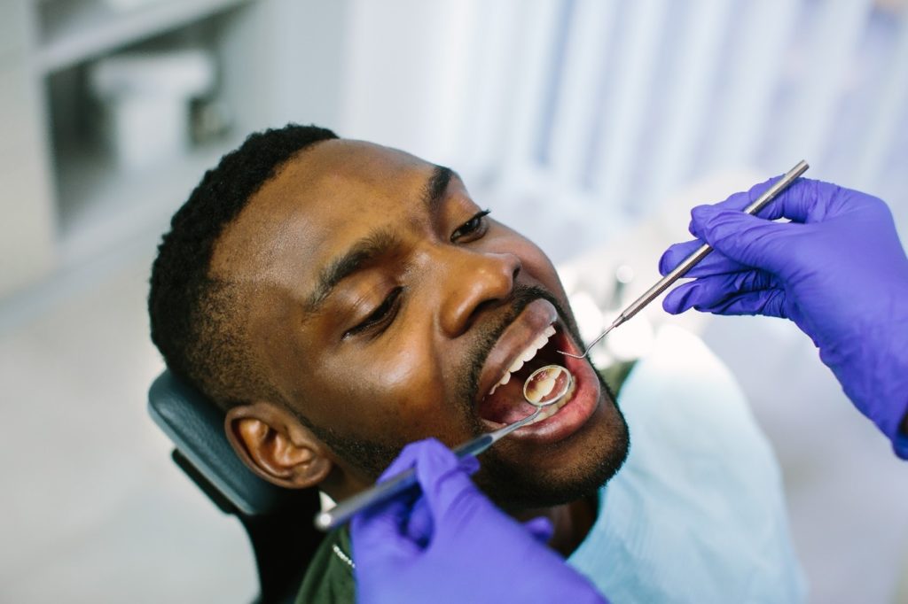 Dentist examining patient's teeth and gums
