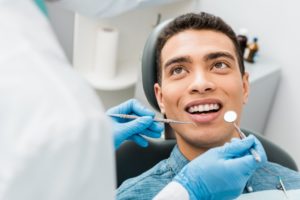 a man smiling while getting his dental checkup