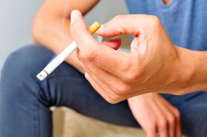 Close-up of man’s hand holding a cigarette