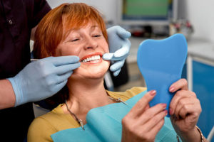 Female patient in dentist’s chair getting dentures